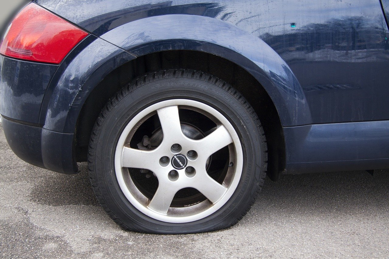 blue car with flat rear tyre