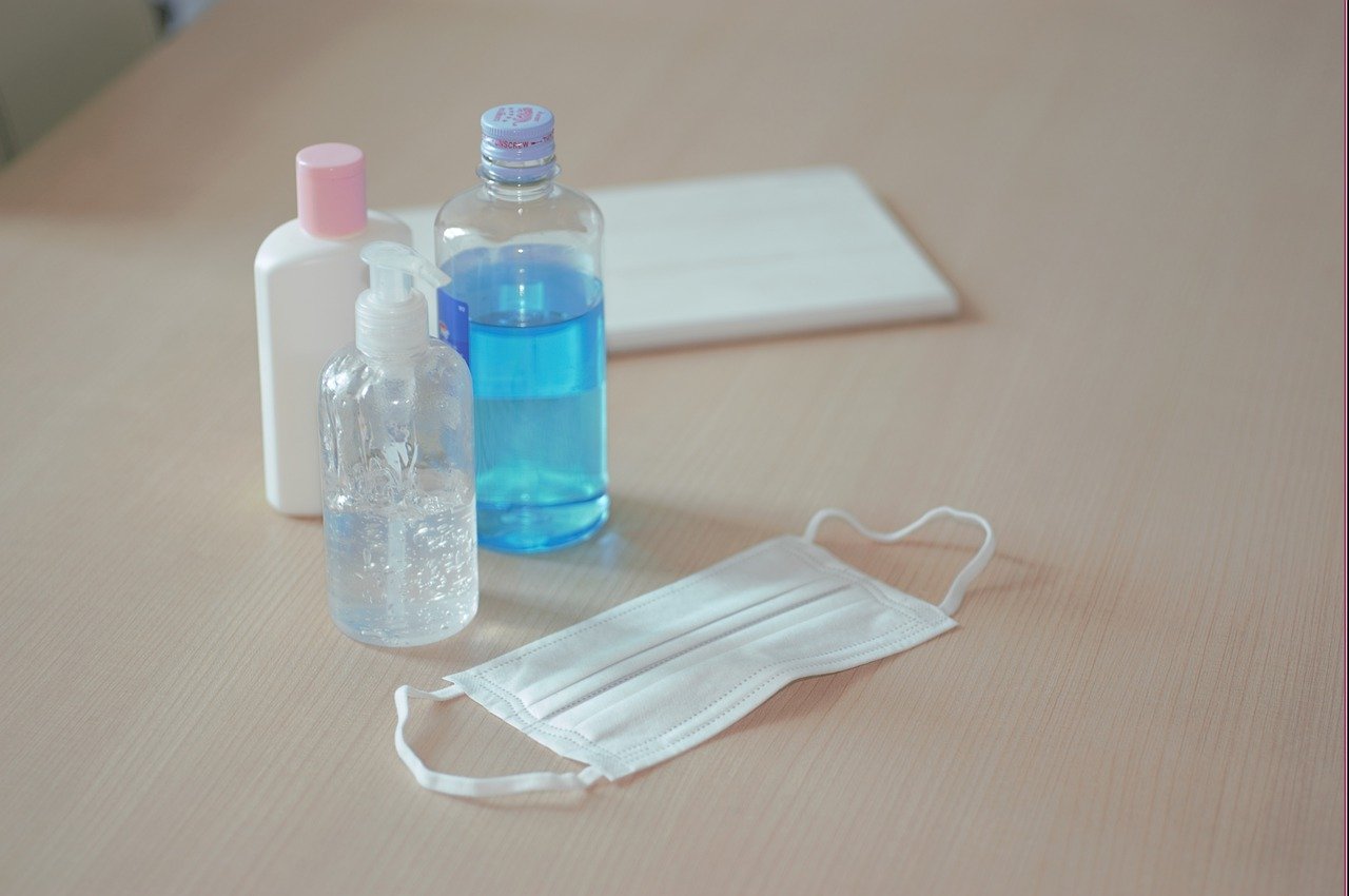 hand sanitiser and face mask on desk